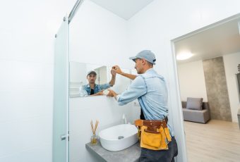 Handyman,Installing,Mirror,In,Bathroom.